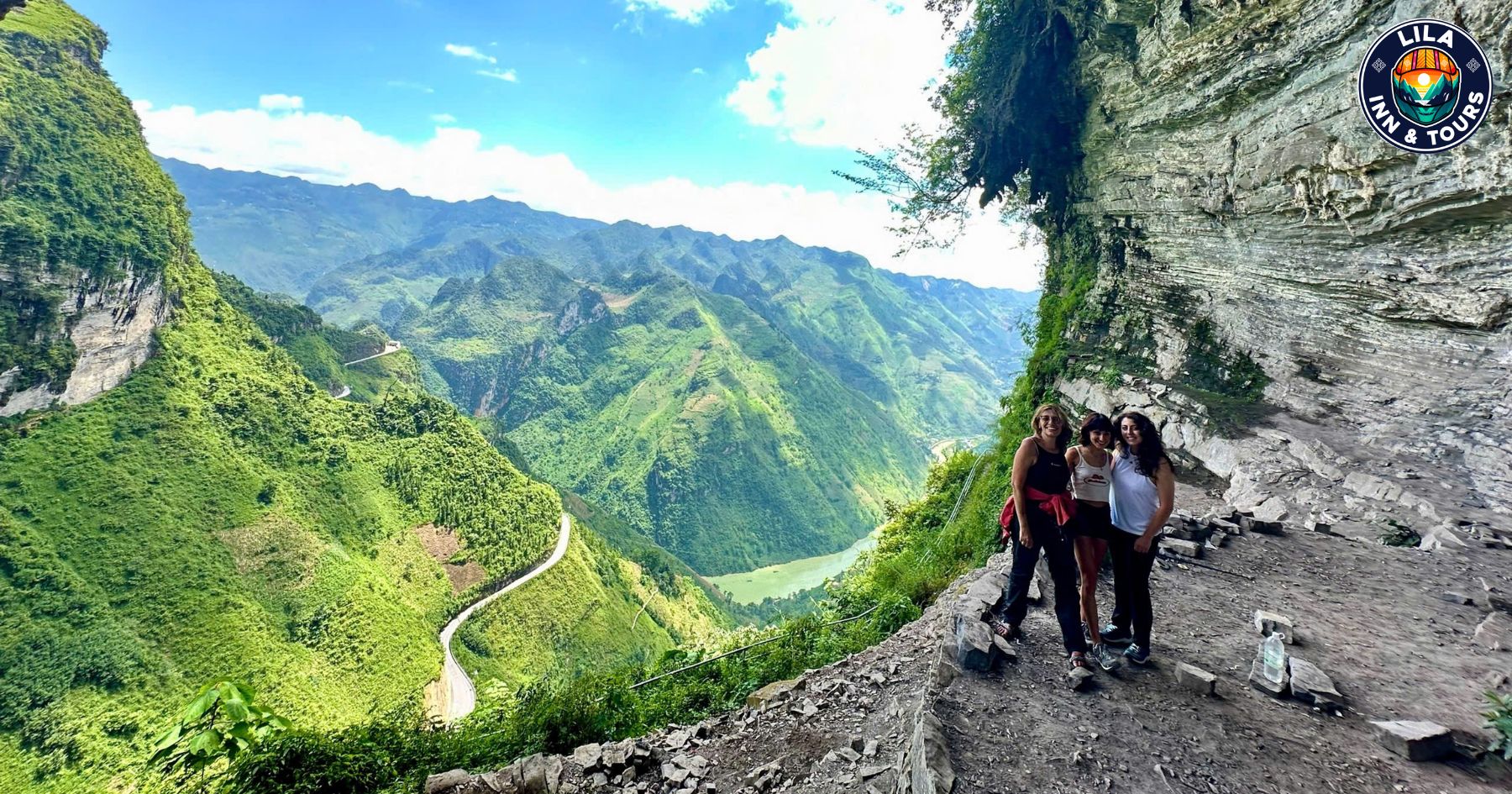 Three female tourists taking photos at the White Cliff on Ma Pi Leng Pass, Ha Giang